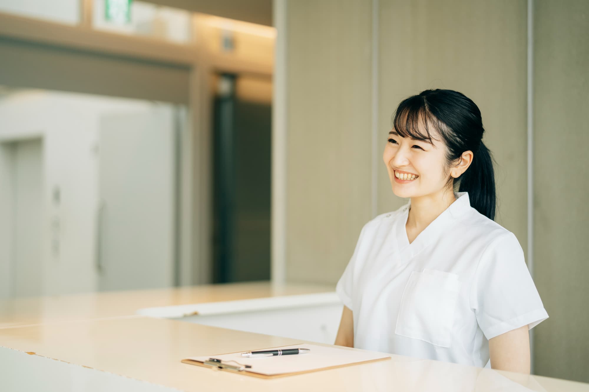 歯科医院の受付で笑顔の歯科衛生士