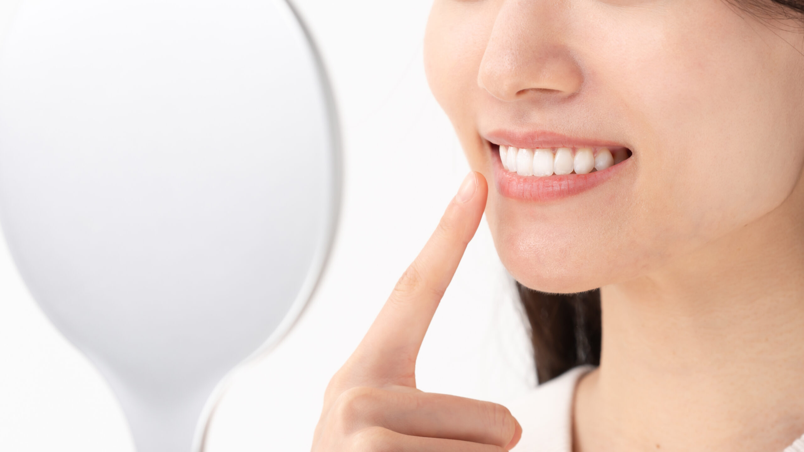 すきっ歯治療をして綺麗になった歯を確認している女性