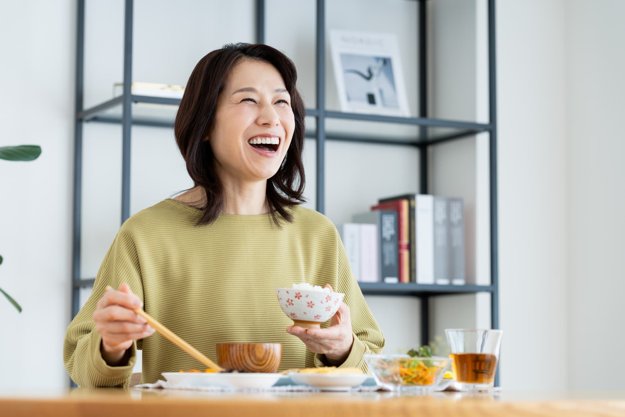 インプラント治療後に適切なケアをして快適に食事をする女性