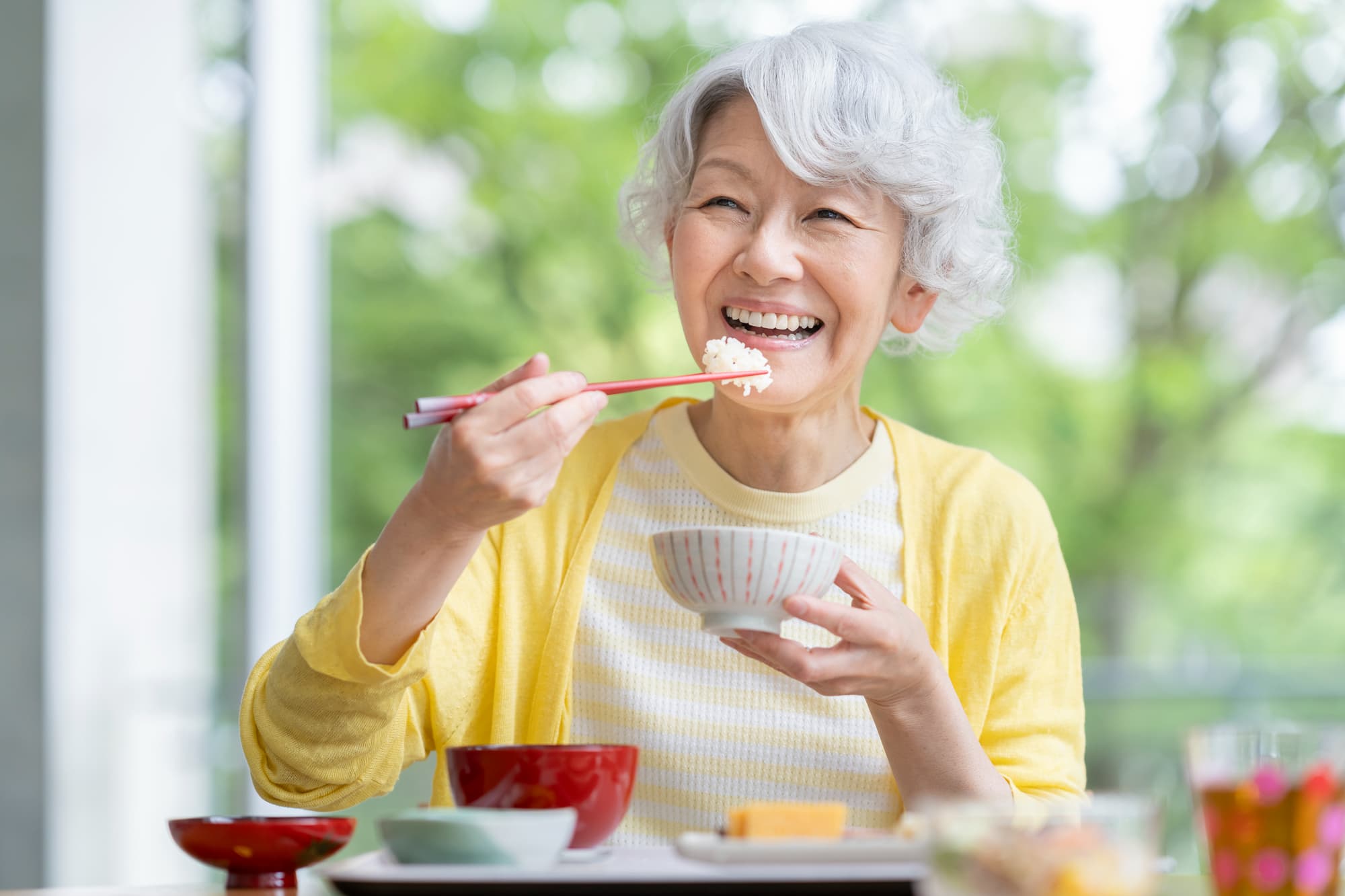 インプラント治療をして快適に食事ができるようになった笑顔の女性