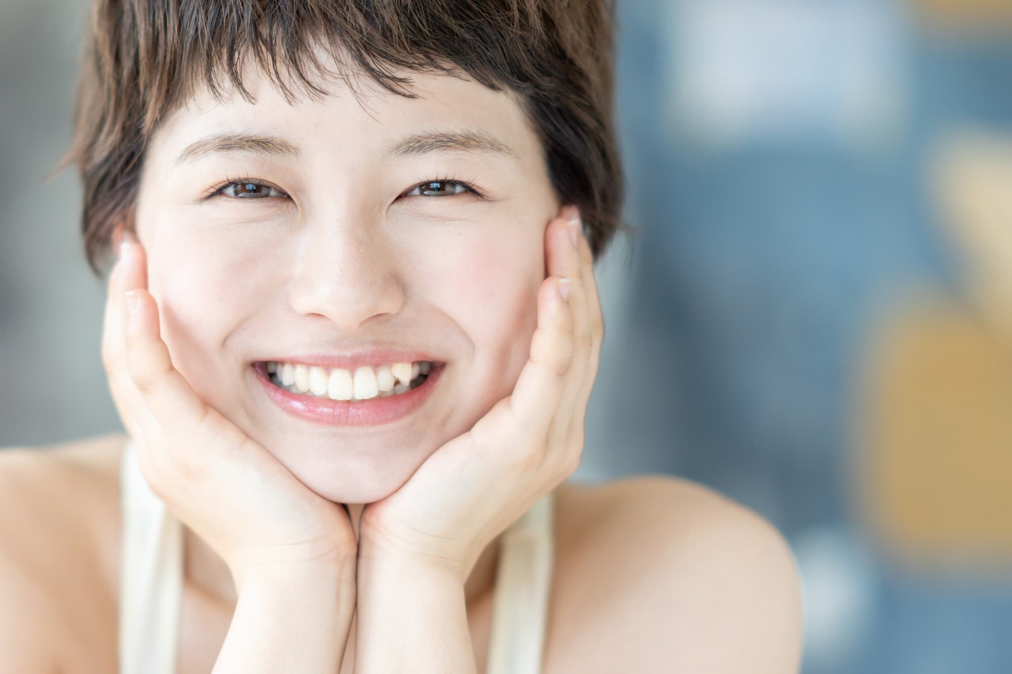 頬杖をついた八重歯の女性
